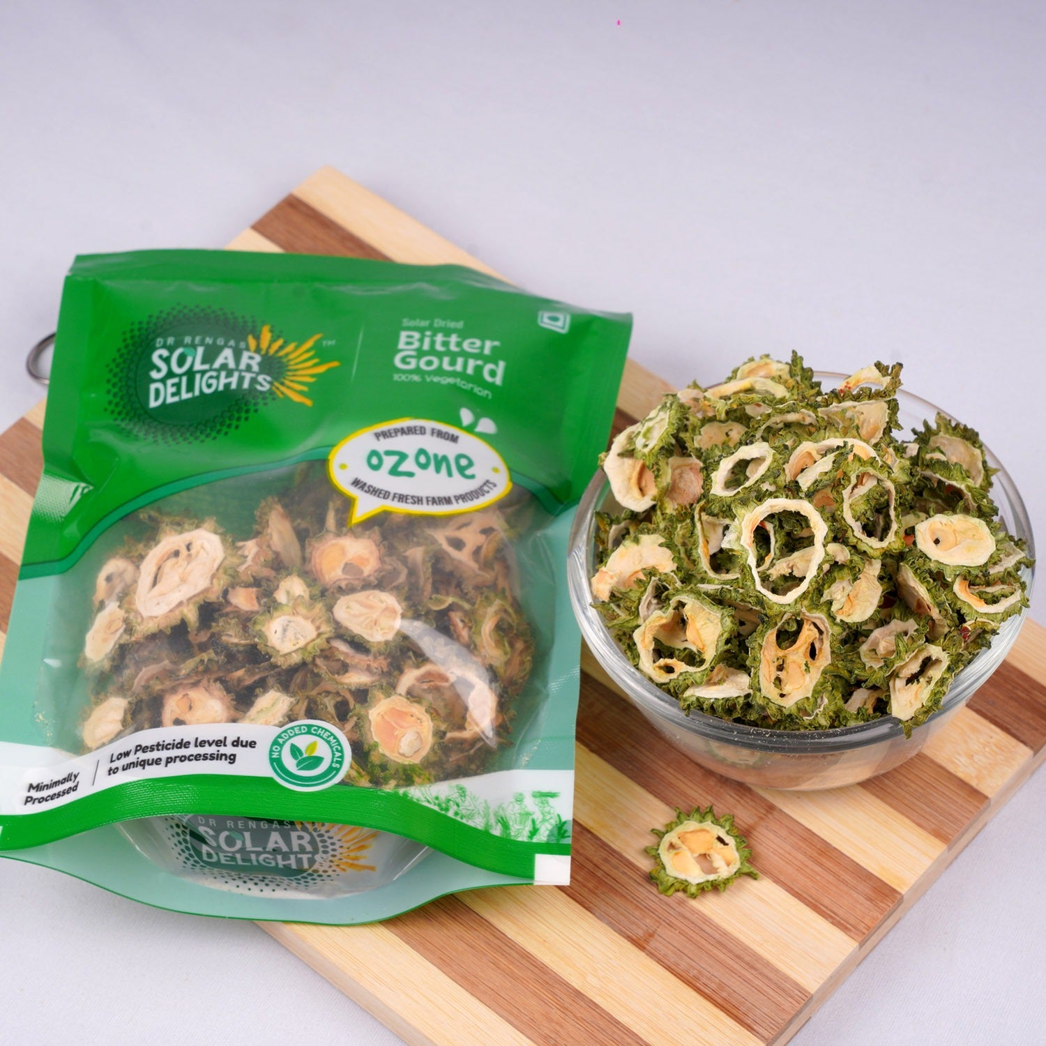 Solar Delights Bitter Gourd snack package with a bowl of snacks on a wooden board.