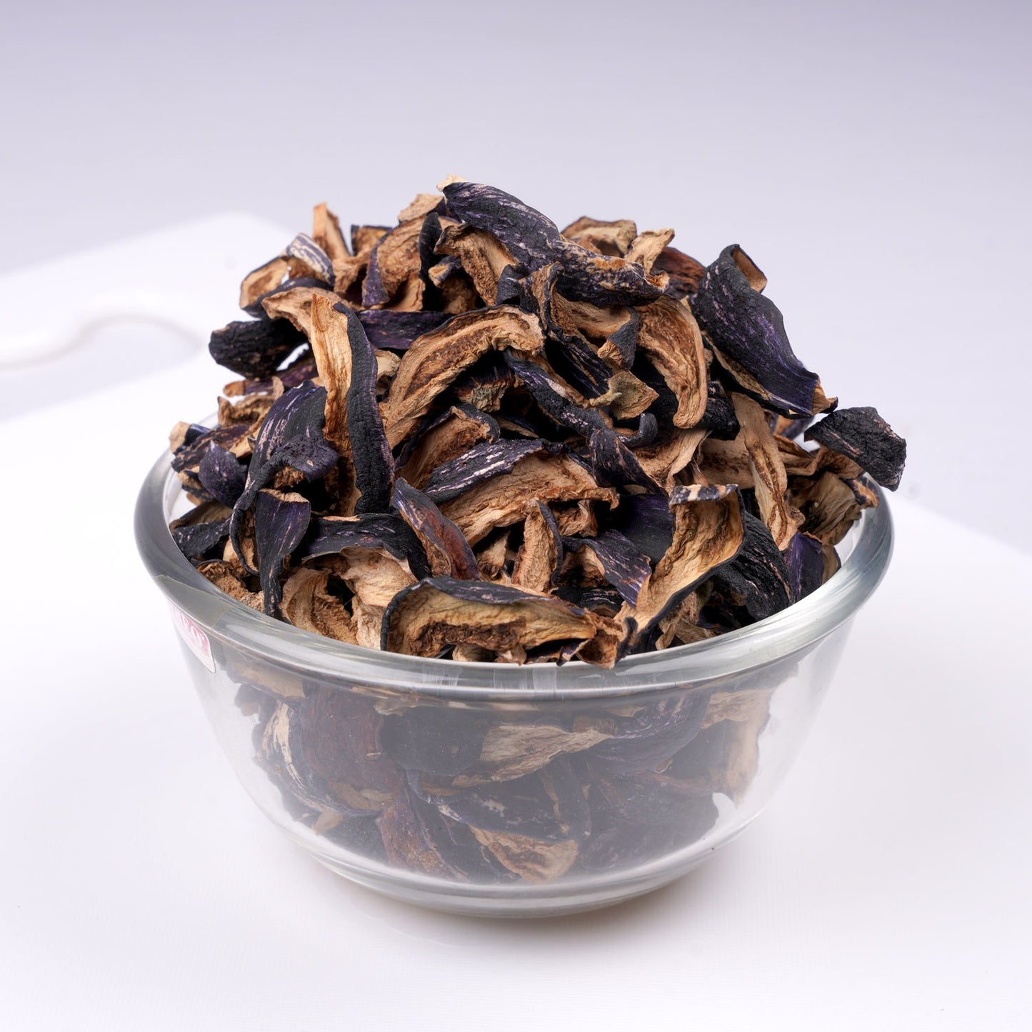 Rich purple color of dried brinjal pieces on a wooden plate