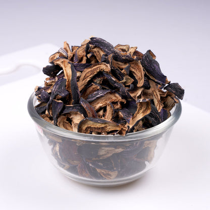 Rich purple color of dried brinjal pieces on a wooden plate