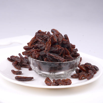 Freshly dried Thompson grapes on a rustic wooden serving plate